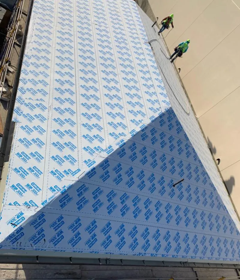 Professional roofers installing underlayment on a metal roof in Davis